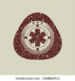 Red emergency cross icon inside distress grunge style stamp