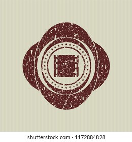 Red film icon inside rubber seal with grunge texture