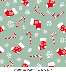 Red fluffy Christmas stockings, candy canes and white snowflakes on green background seamless pattern. Vector Christmas gift socks. Flat vector Illustration. Simple design for web and print