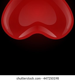Red gel floating balloon in the shape of heart looks from above on a black background.