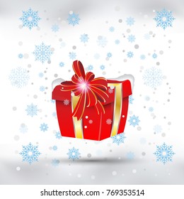 Red gift box with gold ribbons against the snow. Packing for Christmas and New Year.