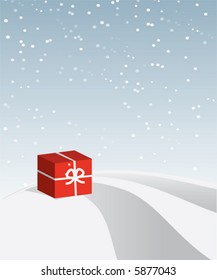 Rote Geschenkbox auf schneebedecktem Hügel.