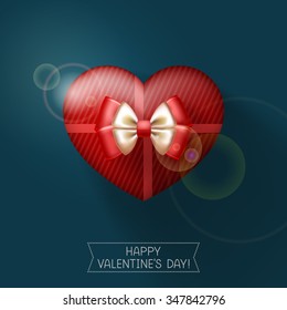 Red gift heart-shaped box, tied with ribbons and decorated with bow, on dark background. Congratulations to Happy Valentine's below