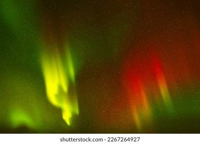 Red green aurora borealis. Night starry sky and Northern lights