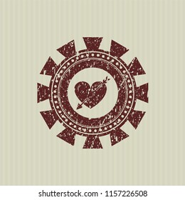 Red heart with arrow icon inside distressed grunge style stamp