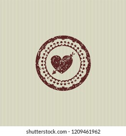 Red heart with arrow icon inside rubber seal with grunge texture