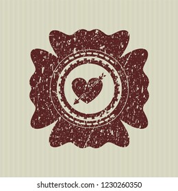 Red heart with arrow icon inside distressed rubber seal with grunge texture