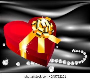 Red heart with golden bow on a background of black silk with pearls decorating