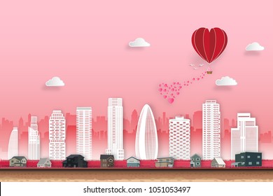 Red heart hot air balloon and cityscape on pink sky as love, happy valentine's day, wedding, paper art and craft style concept. vector illustration.