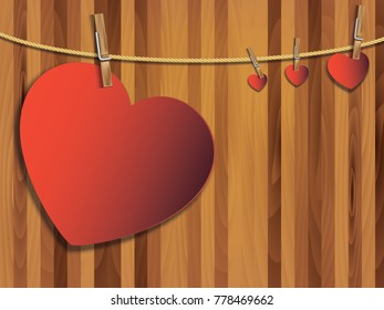 Red heart paper art with wooden clip and rope. Heart shape on wooden background for love concept. Concept of love for valentine day.
