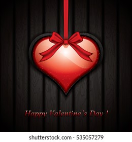 Red heart with ribbon on the wooden background.