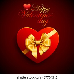 Red heart shape gift with golden bow