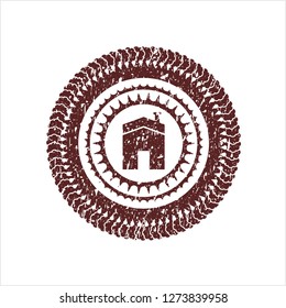 Red house icon inside distressed rubber stamp