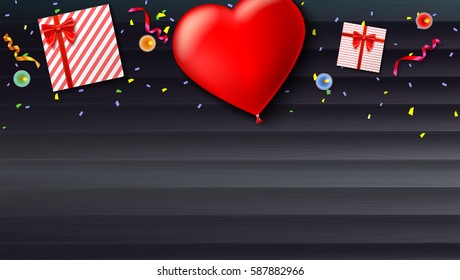 Red inflatable balloon in the shape of a heart with gift boxes, candles, tinsel and confetti on wooden background. Template for creative persons. Best background for holiday, festive greetings cards.