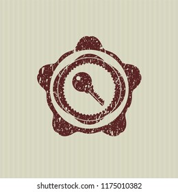 Red key icon inside distressed rubber stamp with grunge texture