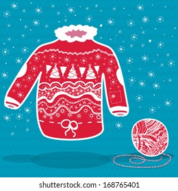 Red knitted christmas sweater and a ball of yarn on blue background