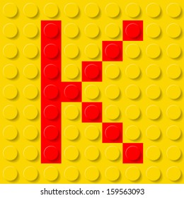 Red letter K in yellow plastic construction kit. Typeface  sample.