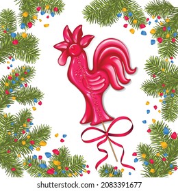 Red lollipop in the shape of a cockerel around branches of a Christmas tree and confetti on a white background.