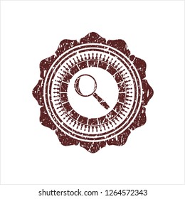 Red magnifying glass icon inside rubber grunge texture stamp