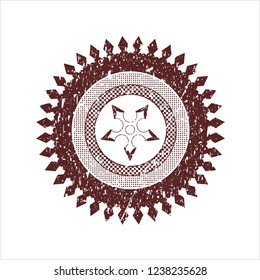 Red ninja star icon inside rubber stamp with grunge texture