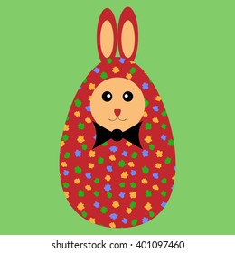 Red painted Easter bunny egg with bowtie on a green background.