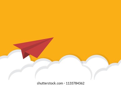 Red paper airplane flying over clouds