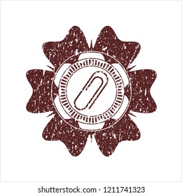 Red paper clip icon inside distressed rubber seal
