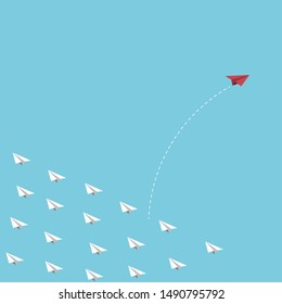 The red paper plane flying out from white paper planes to find freedom, think difference concept.