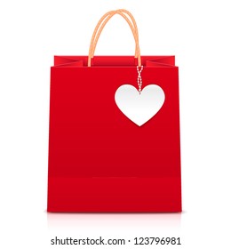 Red paper shopping bag with white heart label on rope of pearls