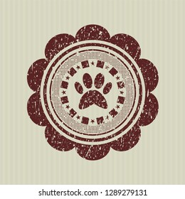 Red paw icon inside distressed rubber seal with grunge texture