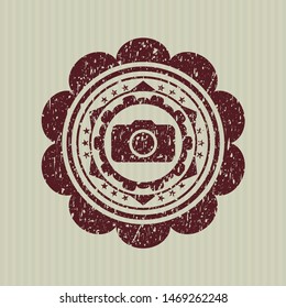 Red photo camera icon inside distress rubber seal with grunge texture
