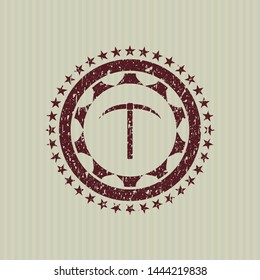 Red pickaxe icon inside distress rubber seal