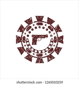 Red pistol icon inside distressed rubber stamp with grunge texture
