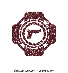 Red pistol icon inside rubber grunge stamp
