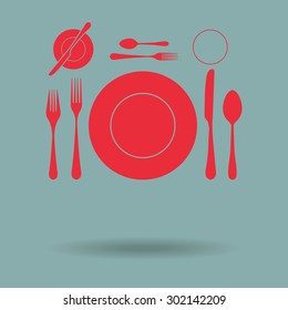 Red plate with spoon, knife and fork 