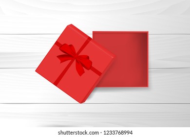 red ribbon with gift box is open on the top of white wooden table. concept design of surprised present gift in Christmas or new year in vector illustration. it also use for marketing and sale template