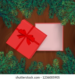 red ribbon and gift box is open on the top of wooden table with christmas tree. concept design of surprised present gift in Christmas or new year in vector. it also use for marketing and sale