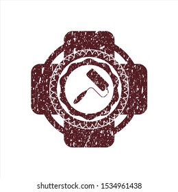 Red roller brush icon inside distressed rubber stamp with grunge texture