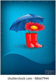 Red rubber boots with a flower placed under a blue umbrella on abstract background