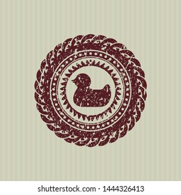 Red rubber duck icon inside rubber stamp with grunge texture