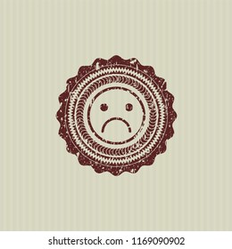 Red sad face icon inside distressed rubber grunge texture seal