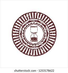 Red sand clock icon inside distressed rubber stamp
