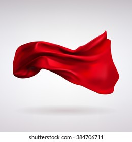 red satin fabric flying in the wind on a light background