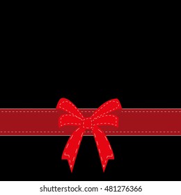 Red satin ribbon with bow isolated over black background