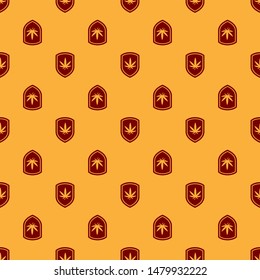 Red Shield and marijuana or cannabis leaf icon isolated seamless pattern on brown background. Marijuana legalization. Hemp symbol.  Vector Illustration