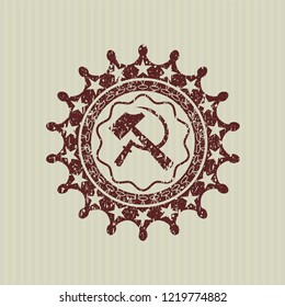 Red sickle and hammer icon inside distressed rubber texture