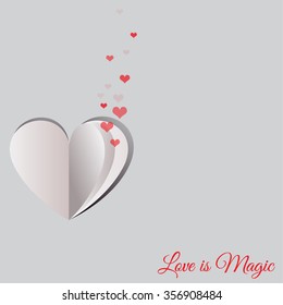 Red small hearts coming out from a fold paper heart shape on white background for Happy Valentine's Day celebrations. Love is Magic text message