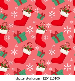 Red sock with candy canes and holly berries branch with gift box and snowflakes ornate seamless pattern on pink background. Design for winter holidays greeting season wrapping papers etc.