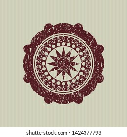 Red sun icon inside distressed rubber texture