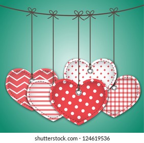 Red textured hearts tied with bows hanging on green background. Vector illustration